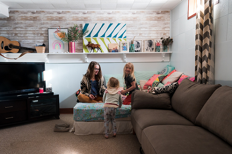 A mother and her two daughters playing on a matress in their living room by Denver, Colorado photographer Elizabeth Osberg